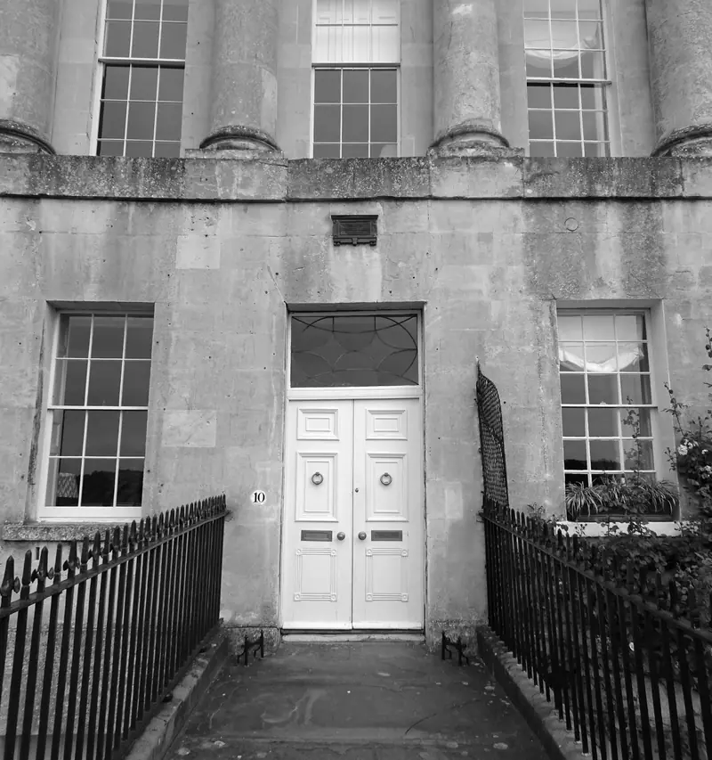 Stone Georgian entrance with white double doors and railings